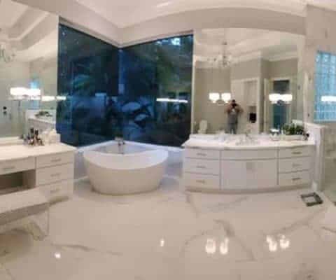 Luxurious Palm Beach bathroom remodel featuring marble flooring, modern freestanding bathtub, glass shower enclosure, and elegant double vanity.