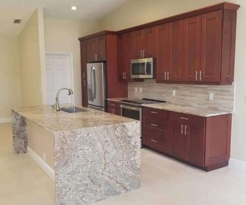 Modern kitchen remodel in Palm Beach featuring elegant granite countertops, custom cabinetry, and stainless steel appliances, ideal for home renovation and luxury design.